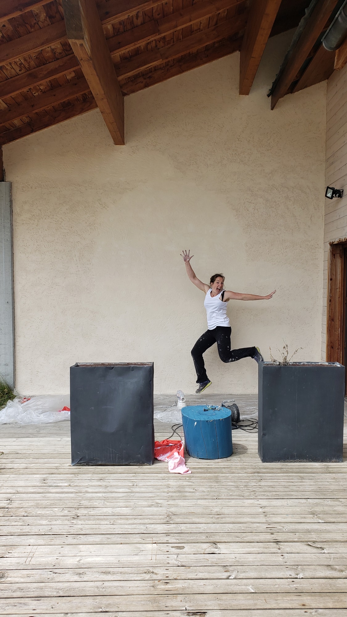 Léa sautant de joie après avoir repeint la façade de l'ancienne fromagerie du Ripioupiou à Autrans